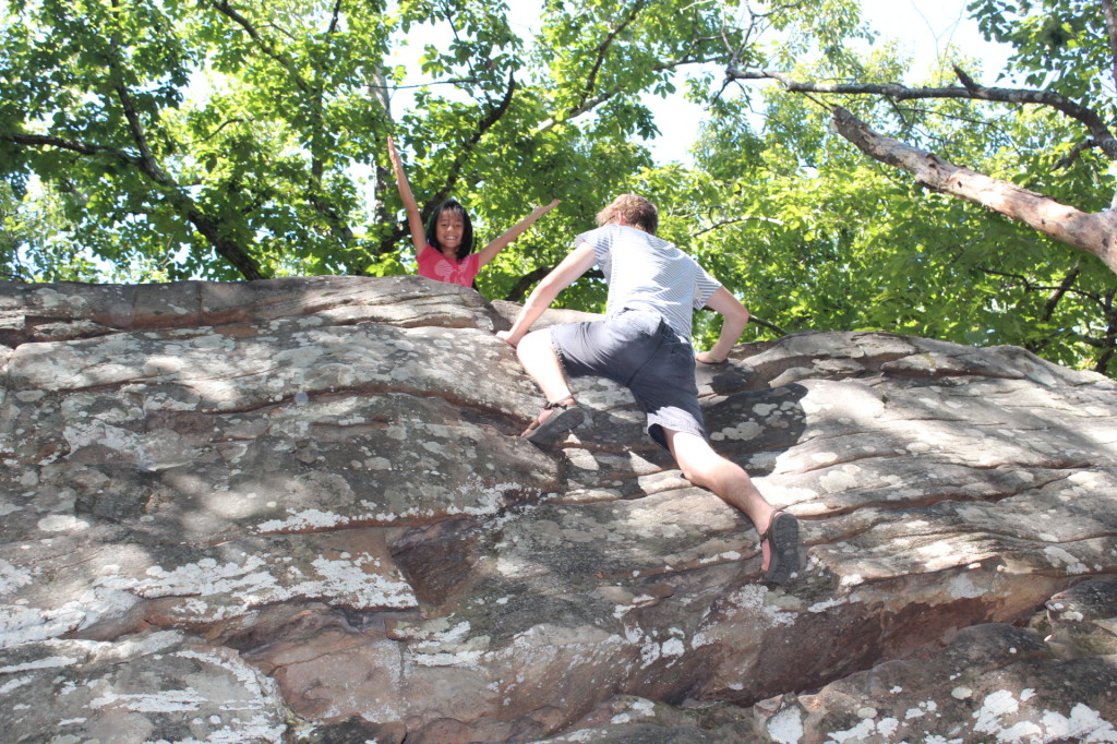 All smiles -- a young girl at the top of the bouldering hill. Teen guy is finishing his climb.