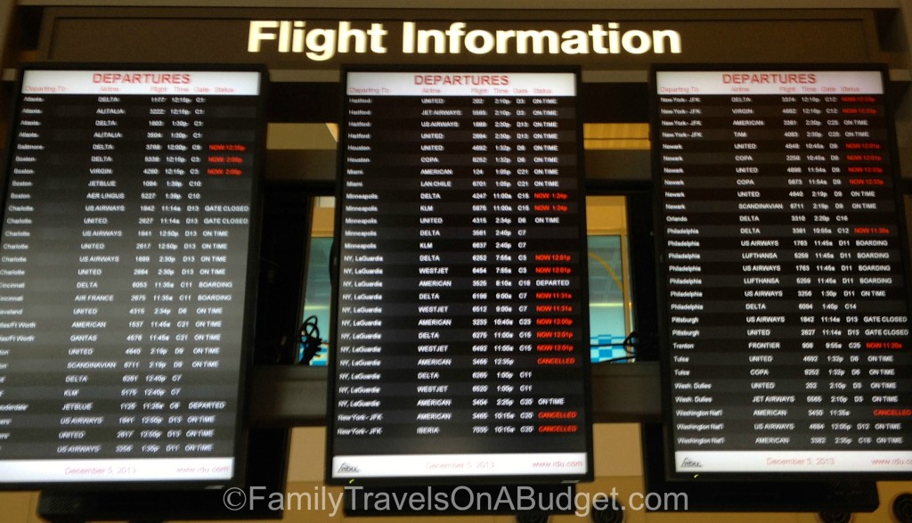 Airport flight departure board shows all flight destination cities in alphabetical order.