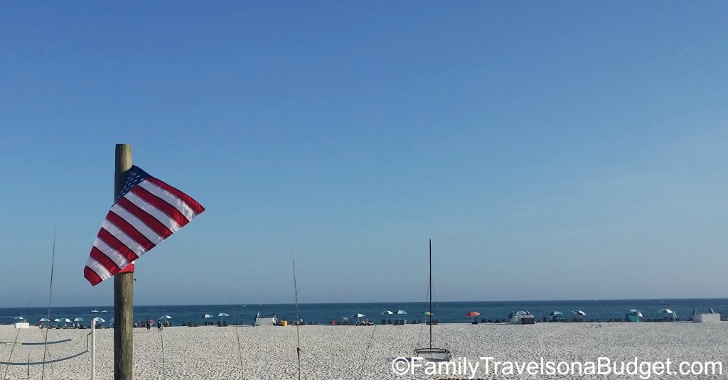 American flag in foreground with beach and gulf ocean beyond