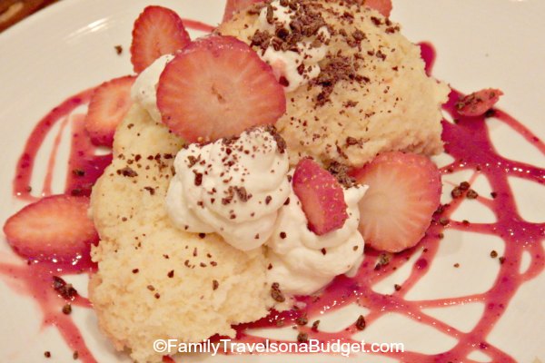 An artisan dessert of strawberries and cream over a biscuit.