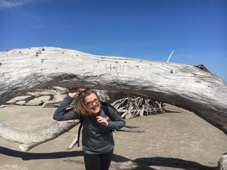 Driftwood Beach photography: Ducking under a fallen tree arch, giggling as we play.