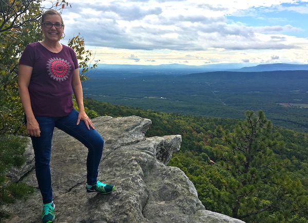 Woman standing on Rock overlooking the Blue Ridge Mountains, part of the Eagle Rock Trail for family hiking vacations.