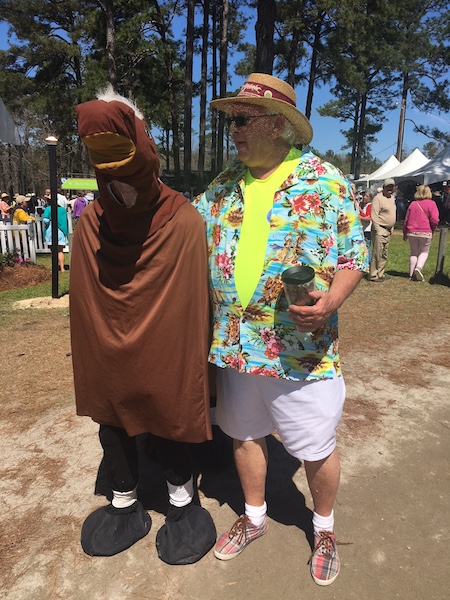 Men dressed for the fun of it at the Carolina Cup, one as a horse and they other in beach attire with a straw hat.