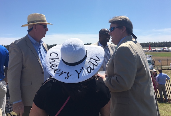 Men in jackets, some with hats. And women in broad brimmed hats are perfect Carolina Cup outfits.