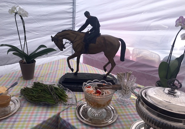 Tailgating tent, with statues, flowers, table cloths and crystalware. 