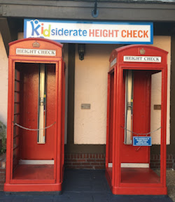 Red phone booths where kids can get wrist bands for ride heights.