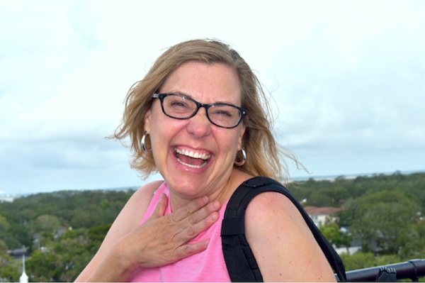 Karen in pink shirt laughing -- author of Family Travels on a Budget