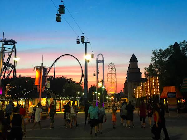 Cedar Point midway at night shows rides, rollercoasters as the sun sets