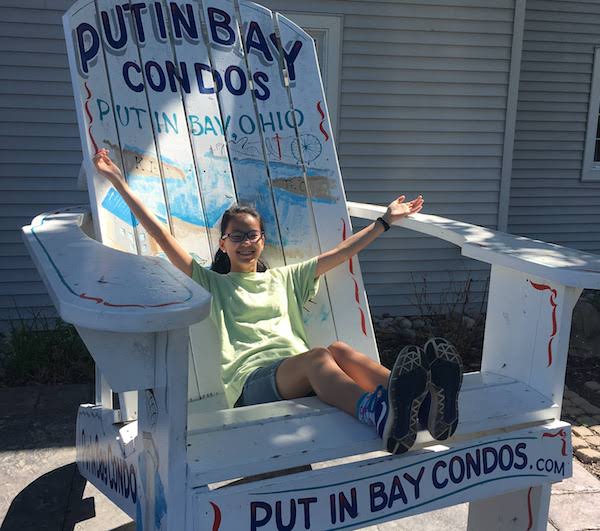 Our daughter posing in the giant adirondack chair at Put In Bay Condos.