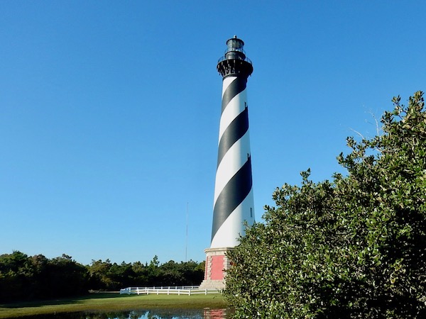 Cape Hatteras Lighthouse in Buxton, at the Outer Banks of North Carolina. Black and white diagonally striped light house with red brick base