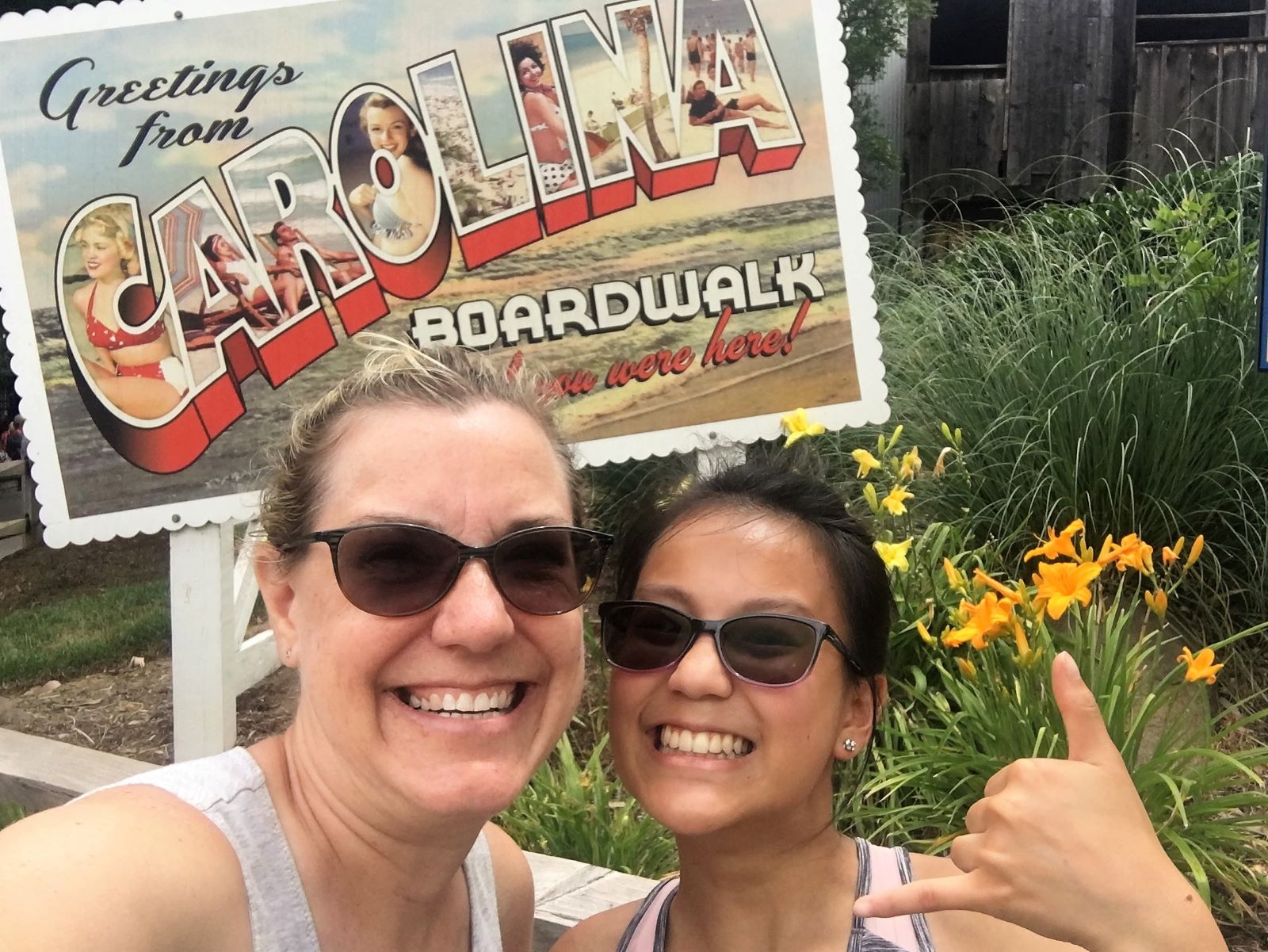 Grinning in front of the Carolina boardwalk sign at the amusement park in NC -- one of the thematic elements celebrating the Carolinas