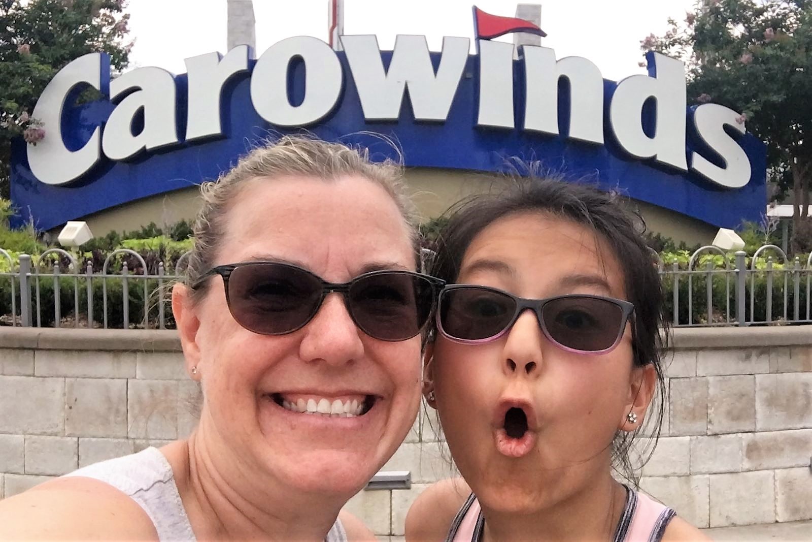 Welcome to Carowinds amusement park in NC -- two faces grinning for the camera in front of the main entrance