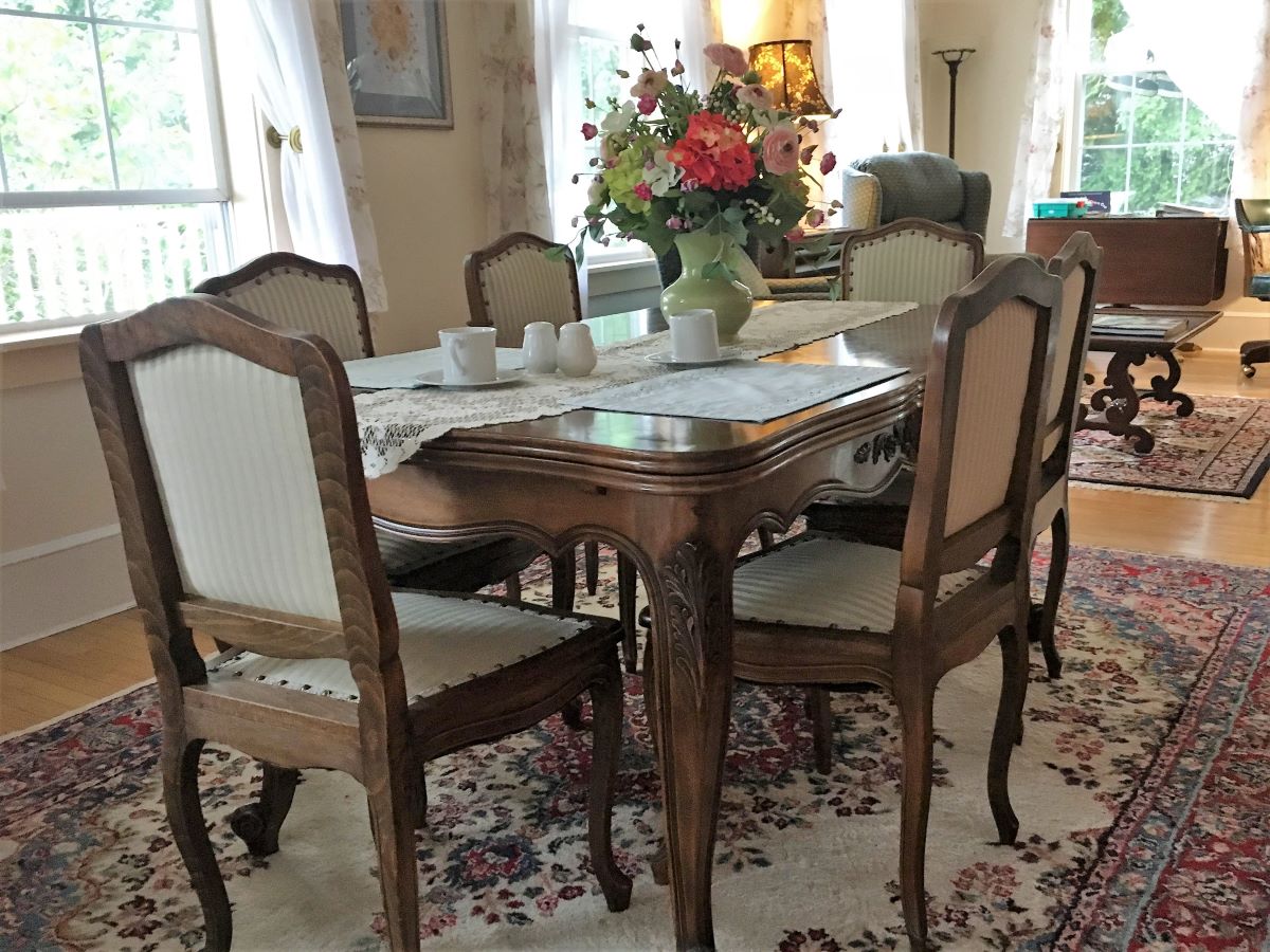 Dining table with six chairs and floral centerpiece