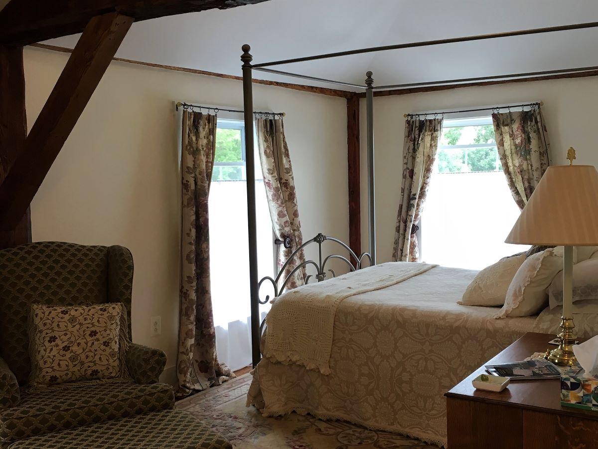 Bed, rustic wooden beams and windows make a cozy space