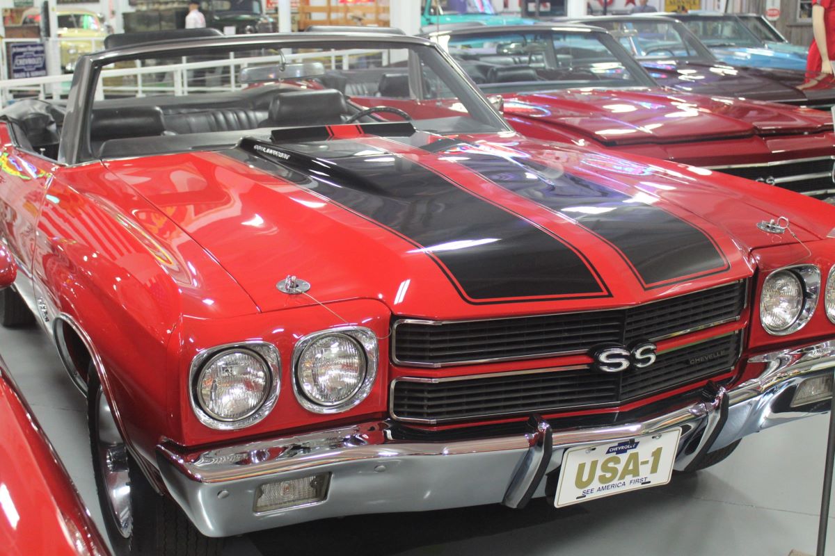 Red Chevyrolet Muscle Car convertible with black stripes on the hood.