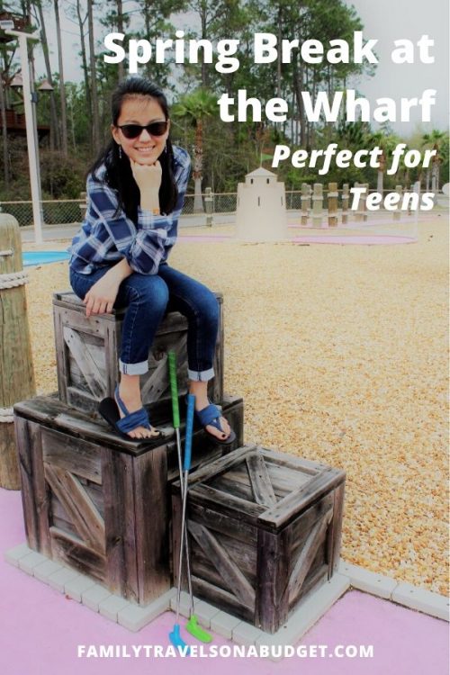 Teen girl sitting on prop at a mini golf course at the Wharf Orange Beach