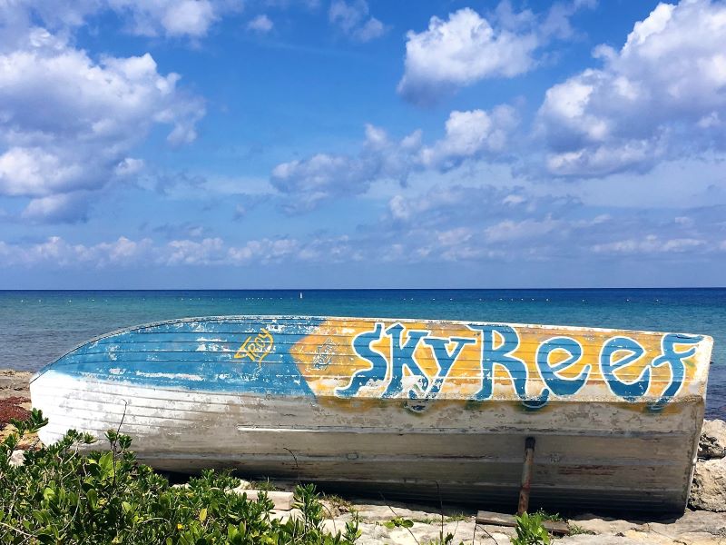 Painted boat on rocky shore in Cozumel