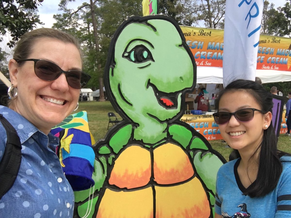 Ellie and I posing for a selfie with the turtle at Festival of Art in Orange Beach.
