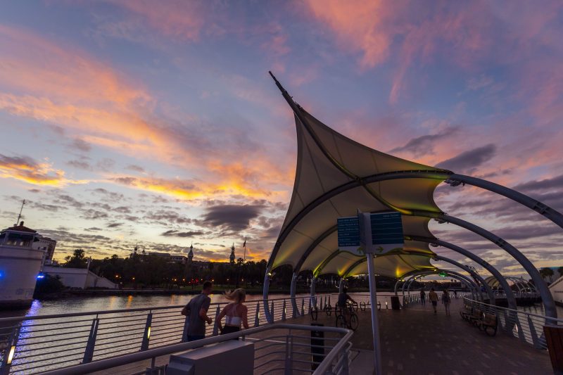 People on the Tampa Riverwalk as the sun sets.