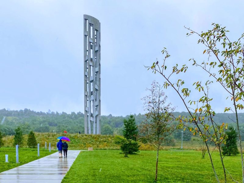 Tower of Voices at United Flight 93 Memorial with trees and visitors in foreground.