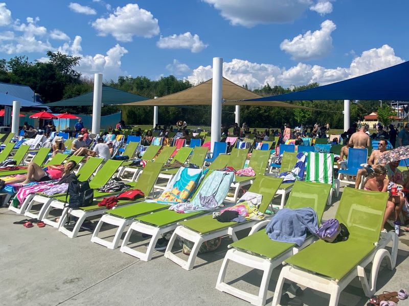 Green and blue lounge chairs with sun shades. 