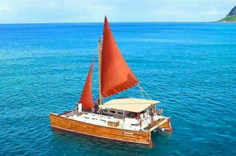 Hawaiian canoe on the Pacific Ocean -- catamaran style boat with orange sails