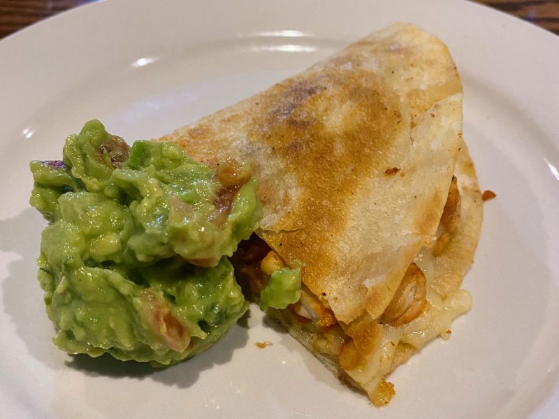 Quesadilla with house made guacamole on a white plate