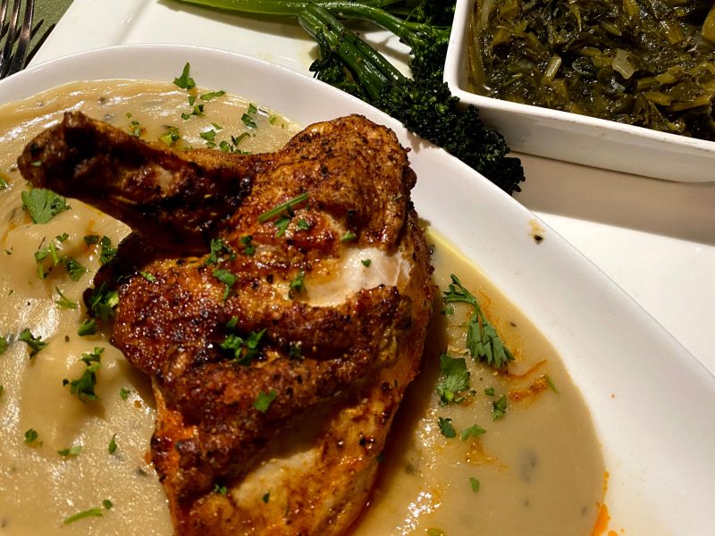Roasted chicken with gravy served with broccolini and collards at Echo on romantic St Simons Island, GA