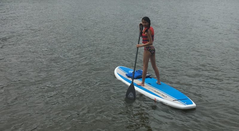 Girl on paddleboard in life jacket