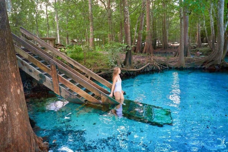 Woman stepping into the hot springs at Ginnie Springs campground in Florida
