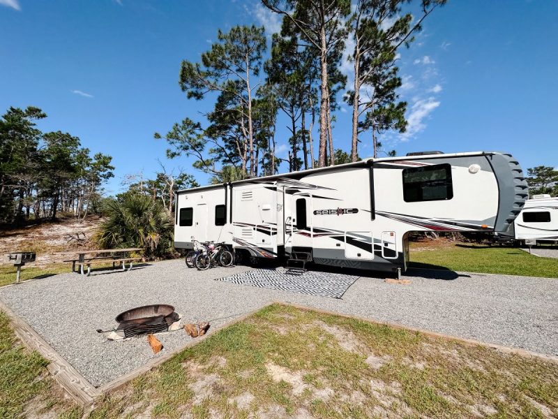 Large RV camping site with fire pit, grill and picnic table at St. Andrews State Park, one place to consider for the best camping in florida for families