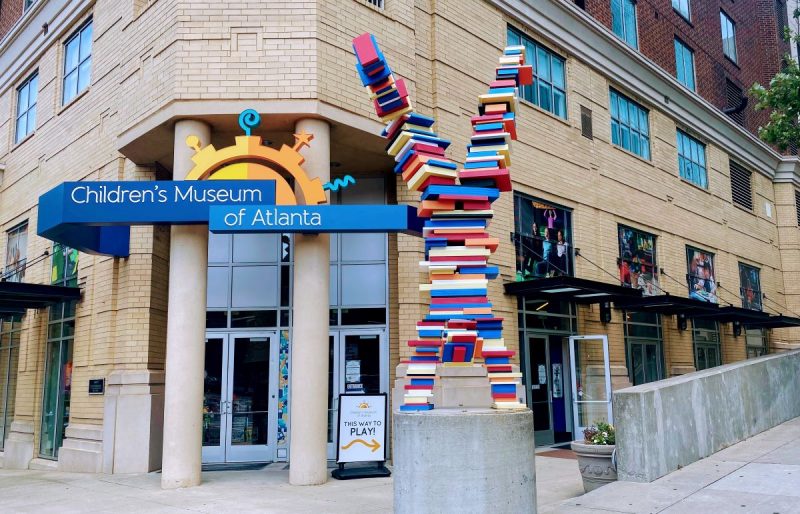 Entrance to the Children's Museum of Atlanta with entrance door open to the right of the statue.
