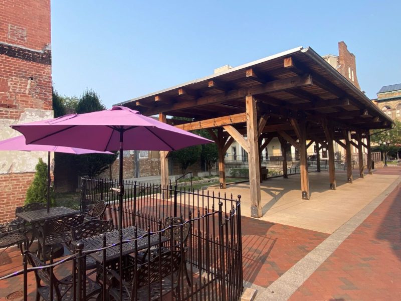 Taylor Pavilion behind Taylor Hotel on the Old Town Winchester Walking Mall. Purple patio umbrellas at iron tables in the foreground.