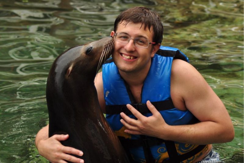 Sea lion kissing a man's cheek