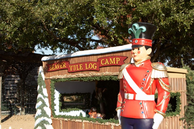 Holiday decorations highlight Grapevine at Christmas, like this full size toy soldier in red, standing outside the "Beaver Yule Log Camp" display, decorated in "snow"