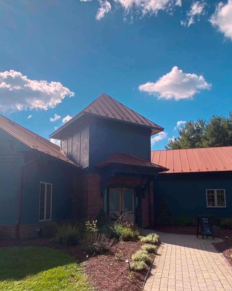 Front entrance to Walsh Family Winery in Loudoun County. Blue siding with copper roof and double doors