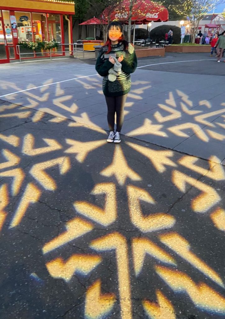 Snowflake projected onto the sidewalk at WinterFest Carowinds makes a fun photo op for our teen!