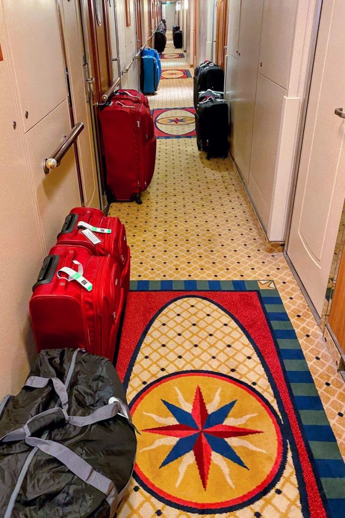 Cruise luggage lined up in hallway of cruise ship