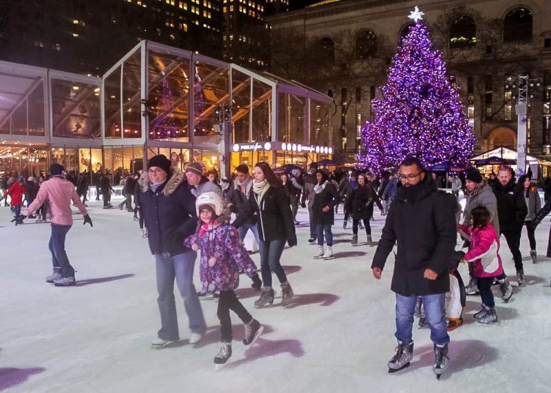Ice skating at Bryant Park Winter Village with the Christmas tree in the background