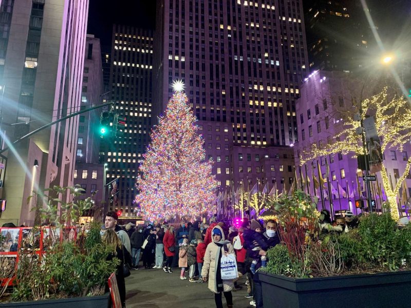 Rockefeller Center Christmas Tree with crowds nearby and skyscrapers all around