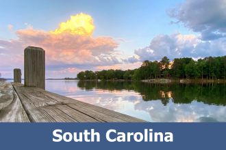 Calm lake with dock in foreground and sky reflecting off the water in South Carolina