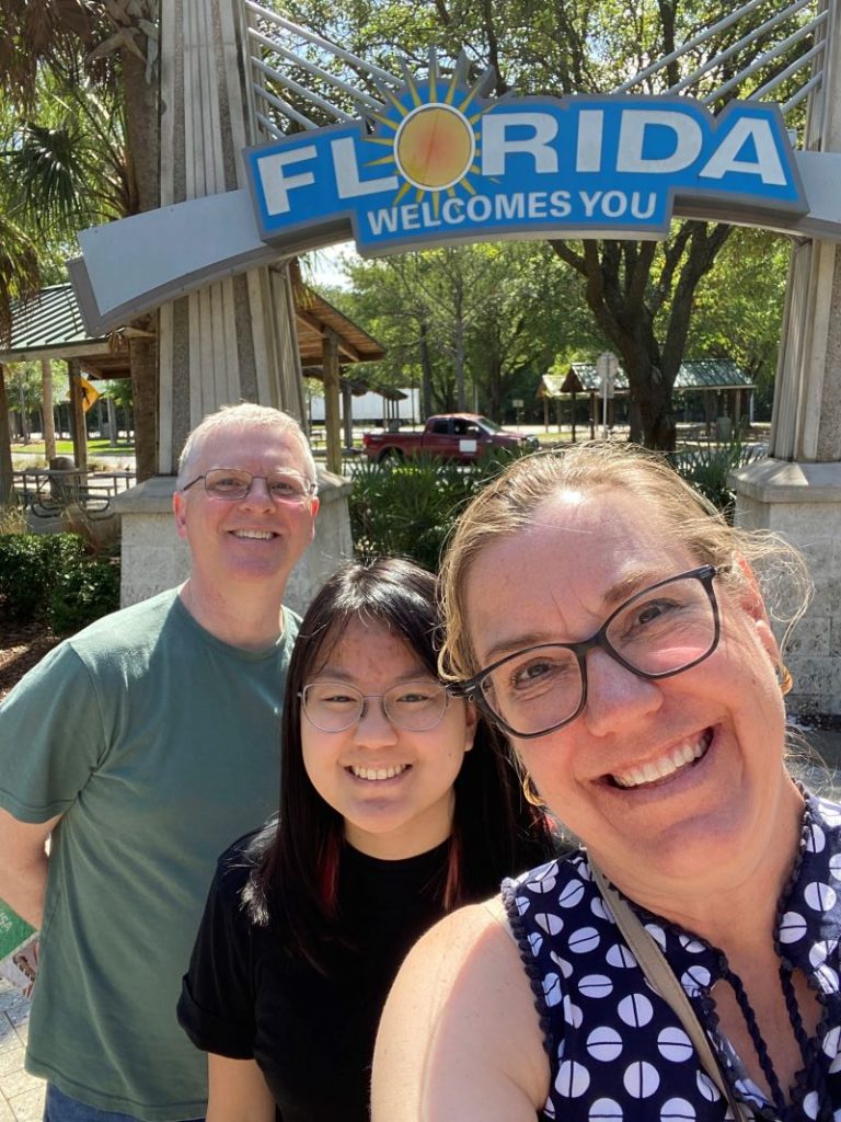 Family smiling at the Florida welcome center on a spring break family vacation.