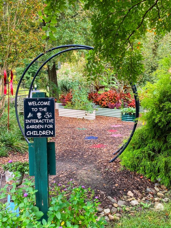 Entrance to the kids garden at Meadowlark Botanical Gardens featuring bright flowers and a fun, circular entrance area.