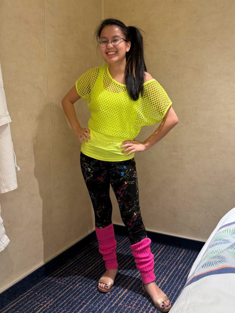 Teen dressed in 80s neon fashion with side ponytail.