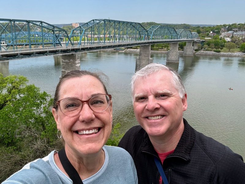 Selfie in front of the Walnut Street Pedestrian Bridge with kayaker in river.