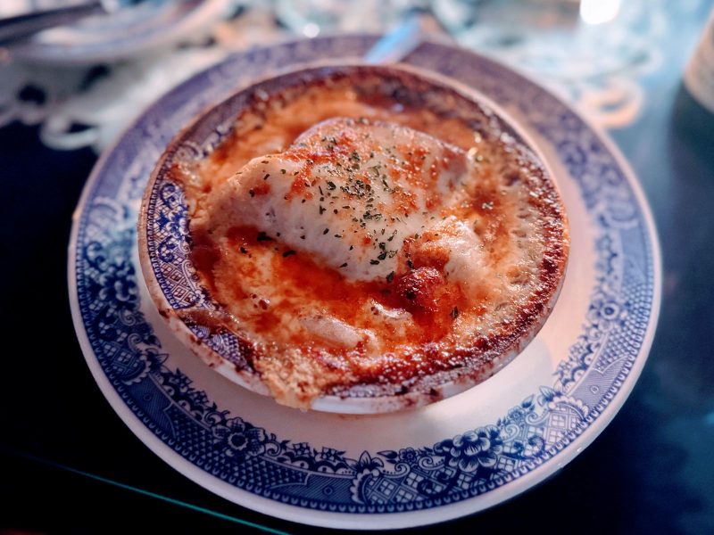 French onion soup in blue and white china bowl.