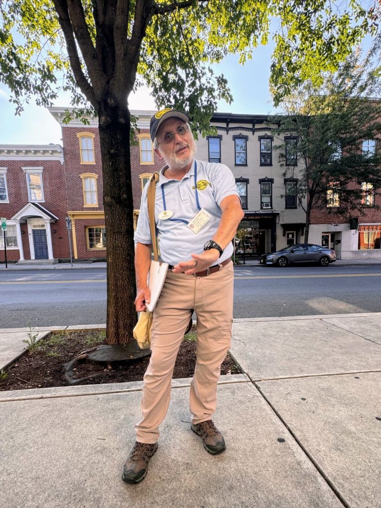 Gettysburg history tour guide with downtown buildings in background.