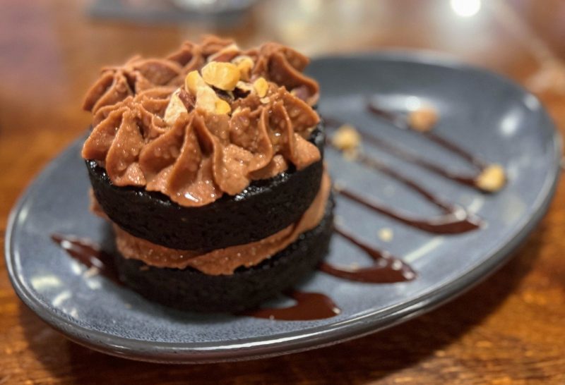 Wolf King Imperial Stout chocolate cake with nutella buttercream and toasted hazelnuts on a gray, stone plate.